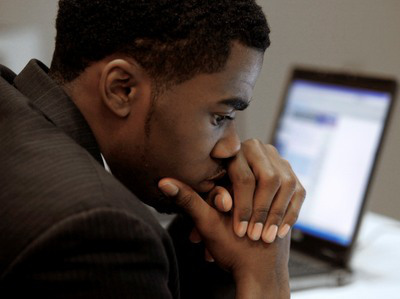 Terrell Collins, of Detroit, pauses while checking employment on a laptop comuter while attending a job fair in Livonia, Mich., Wednesday, Nov. 4, 2009.   (AP Photo/Paul Sancya)